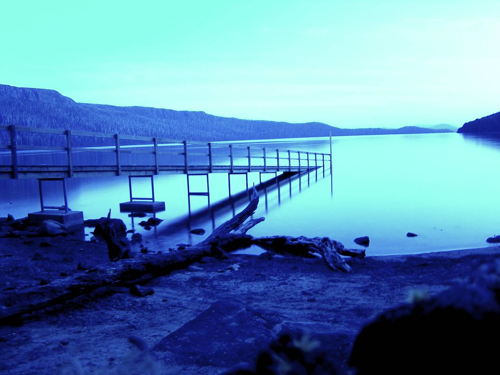 A jetty reaching across the still water of Lake St Clair, Tasmania
